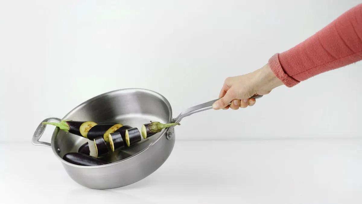 Aplicação de pasta de bicarbonato de sódio em panela de inox.