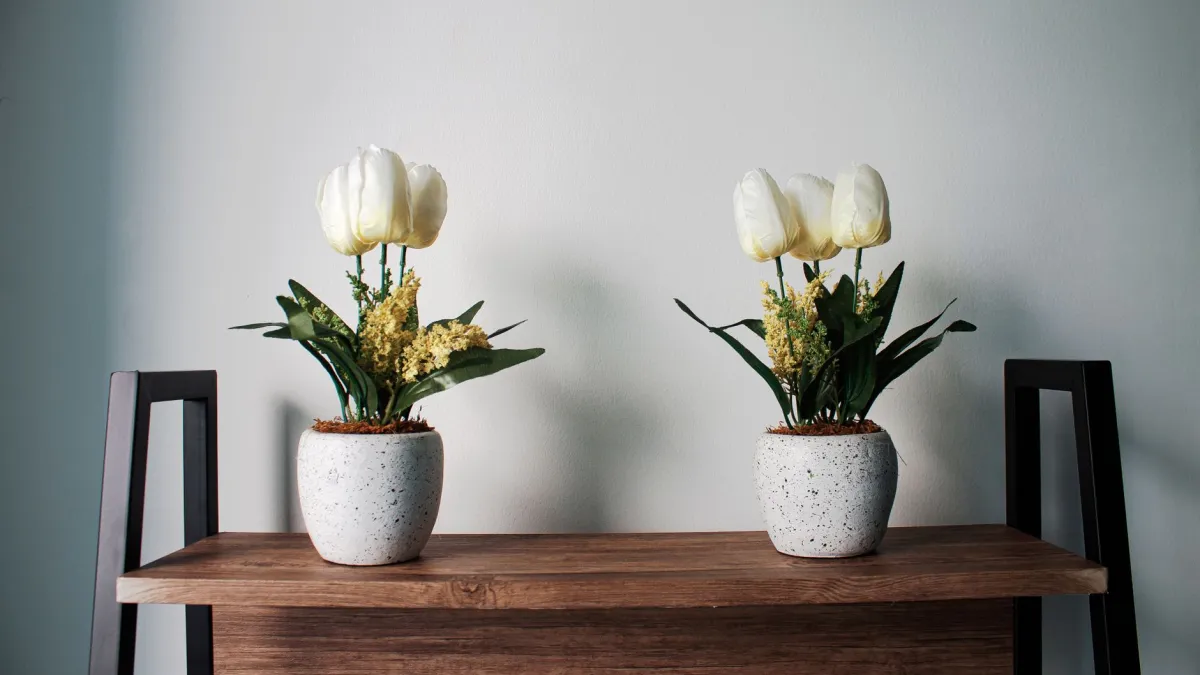 Arranjo de flores de longa duração em um vaso de cerâmica elegante sobre uma mesa de madeira