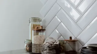 Bancada de cozinha organizada com potes de armazenamento de alimentos de vidro e plástico