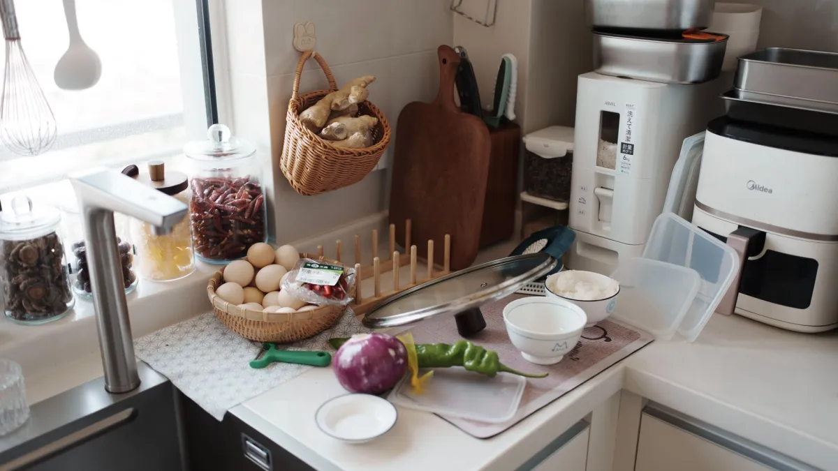 Cesto de air fryer sendo lavado em uma pia com água e espuma de sabão.