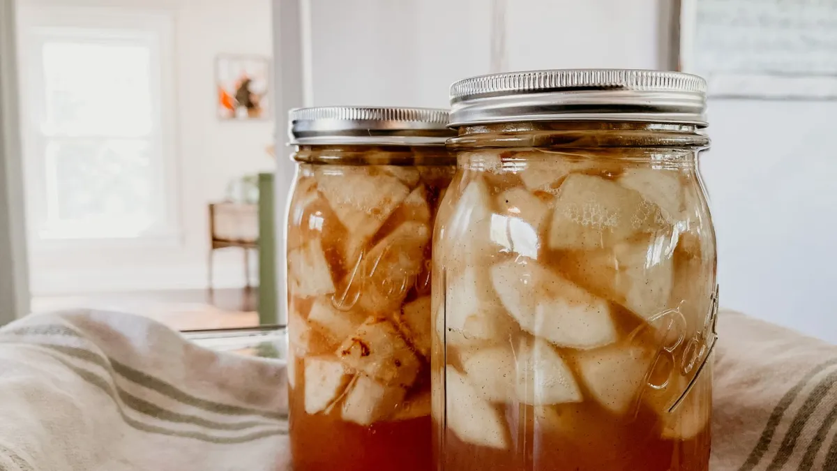 Close-up de pedaços de frutas frescas sortidas em um pote de vidro hermeticamente fechado