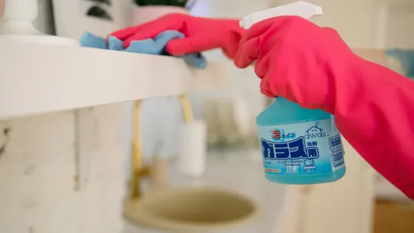 Close-up de rodapé de cozinha sendo limpo para remover acúmulo de gordura com um pano