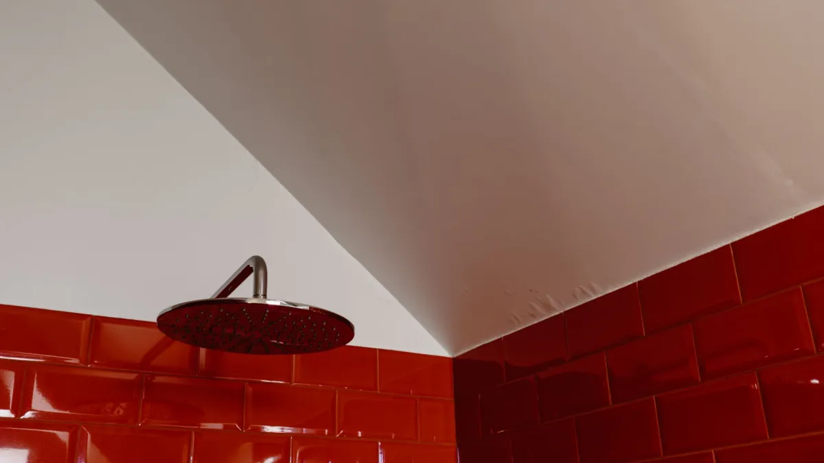 Close-up de teto de banheiro com manchas de mofo e umidade