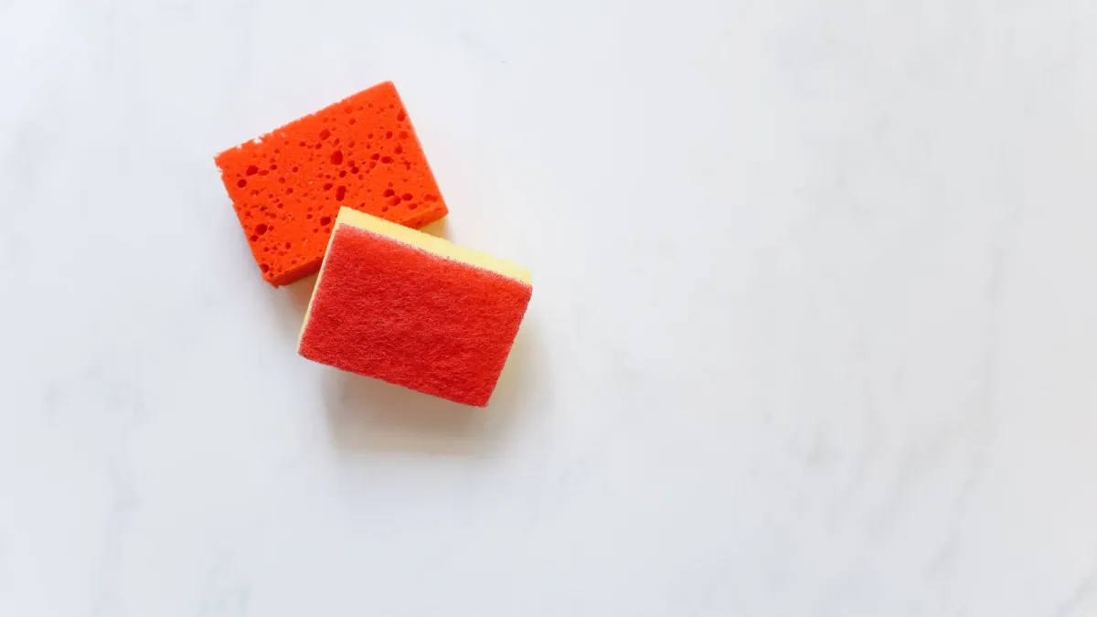 Esponjas de cozinha limpas e frescas dispostas em um suporte.