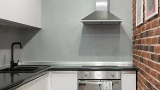 Exaustor de cozinha moderno em aço inoxidável instalado sobre o fogão.