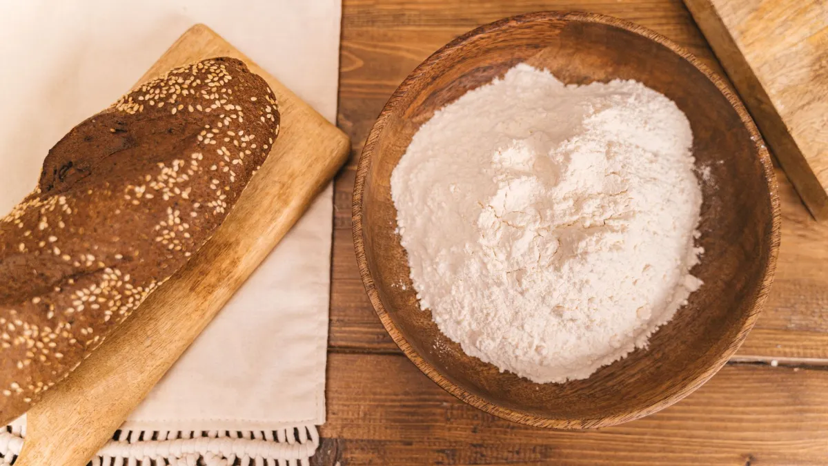 Farinha de rosca caseira em uma tigela ao lado de um pão.