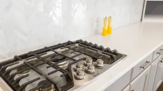 Fogão de cozinha moderno e limpo, com superfície brilhante e queimadores organizados.
