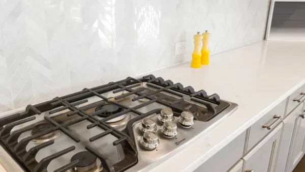 Fogão de cozinha moderno e limpo, com superfície brilhante e queimadores organizados.