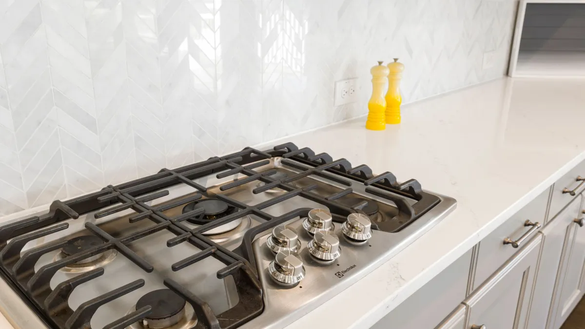 Fogão de cozinha moderno e limpo, com superfície brilhante e queimadores organizados.