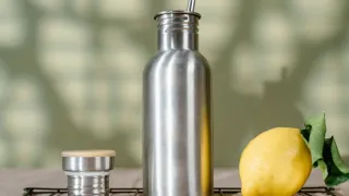 Interior de uma garrafa térmica de aço inoxidável sendo limpo com uma escova macia