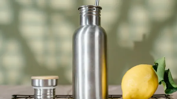 Interior de uma garrafa térmica de aço inoxidável sendo limpo com uma escova macia