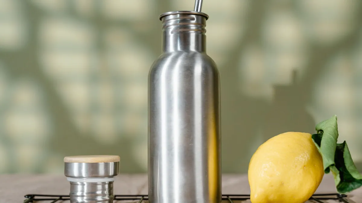 Interior de uma garrafa térmica de aço inoxidável sendo limpo com uma escova macia