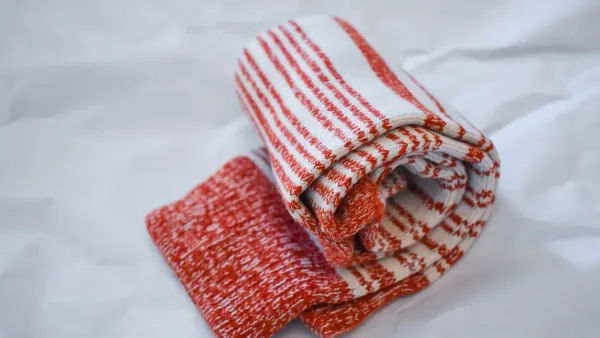 Meias brancas dobradas de forma organizada sobre uma superfície branca e limpa.