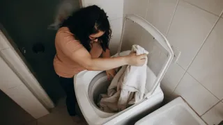 Mulher lavando roupas em um tanquinho antigo