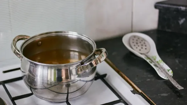 Panela de inox com manchas escuras no fogão.