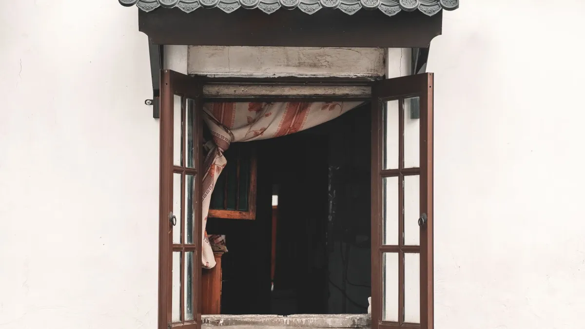 Pessoa abrindo a janela da cozinha para permitir a circulação de ar.