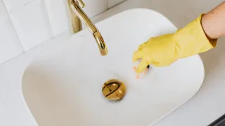 Pia de banheiro com resíduos brancos de produto de limpeza.