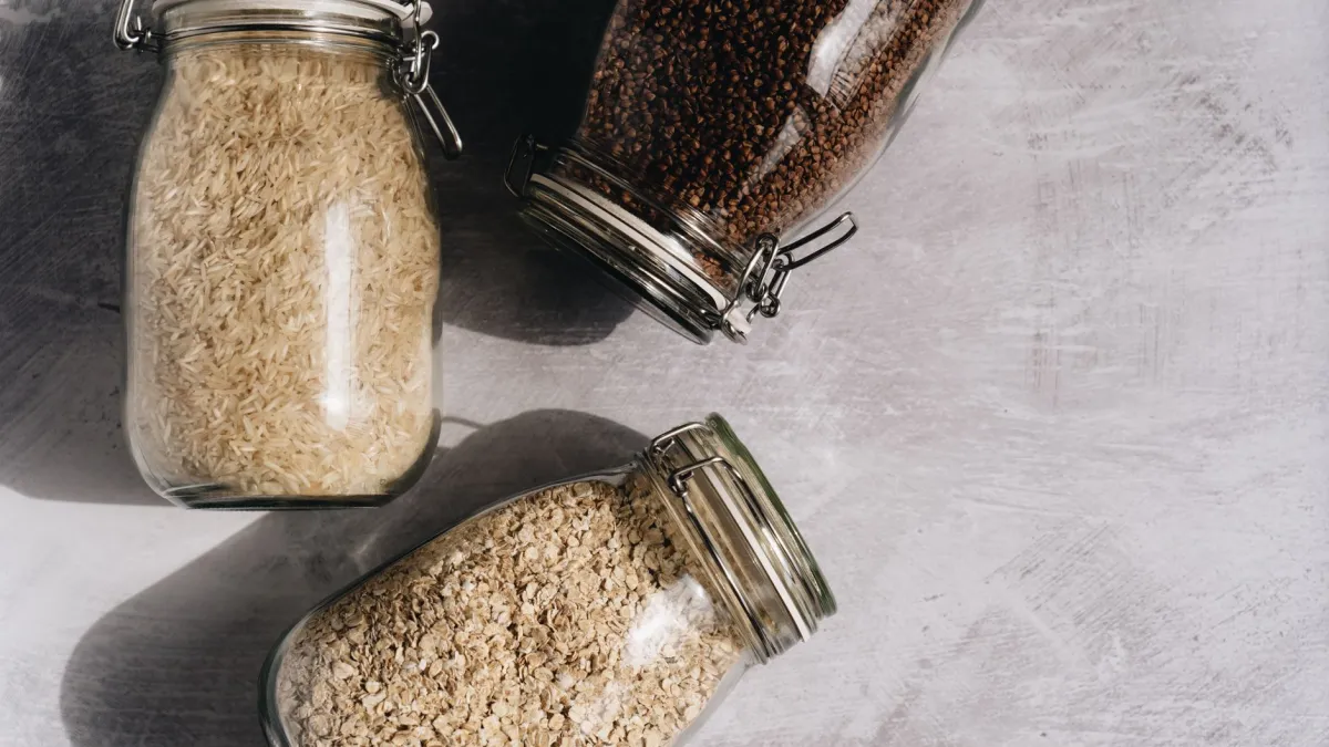 Pote de vidro com arroz cru e folhas de louro secas para conservação