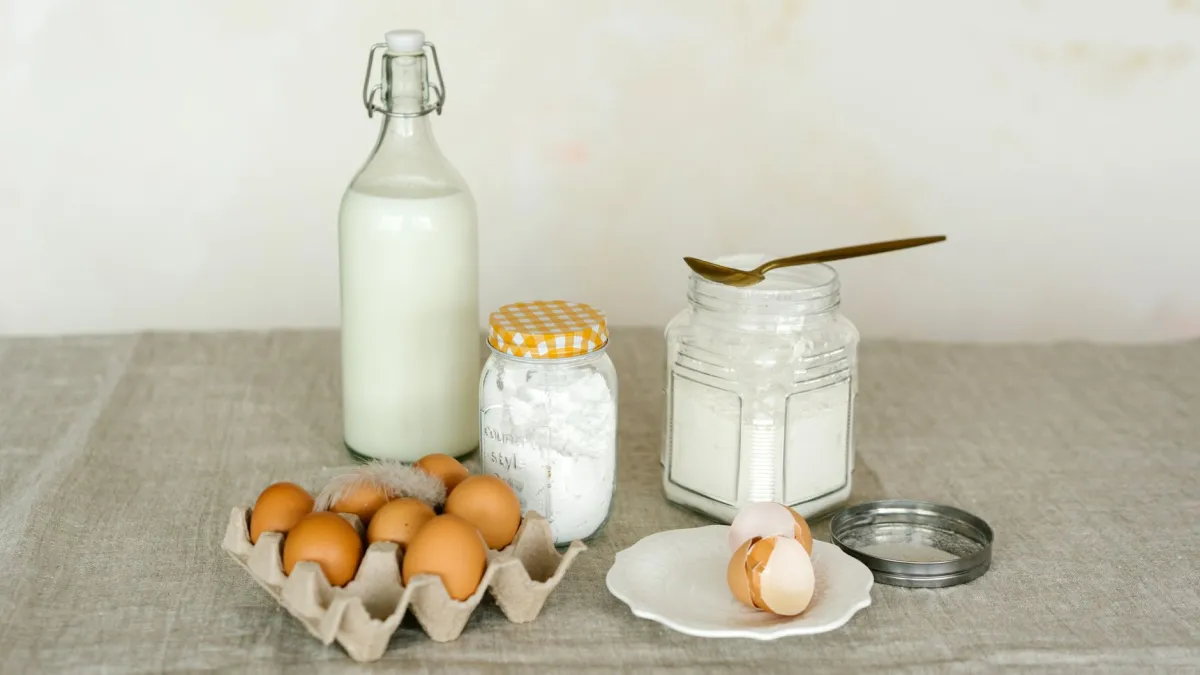 Recipientes com bicarbonato de sódio e vinagre branco em uma bancada de cozinha.