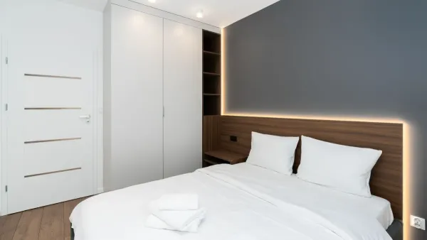 Roupas de cama brancas e dobradas de forma organizada em um armário