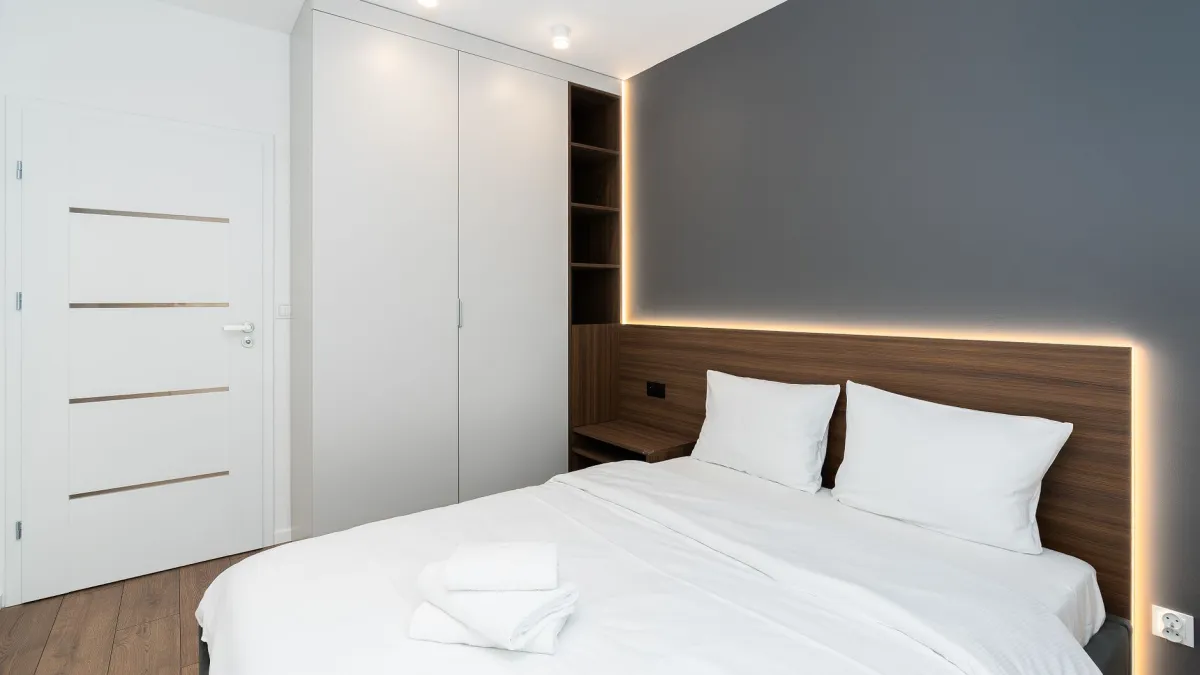 Roupas de cama brancas e dobradas de forma organizada em um armário