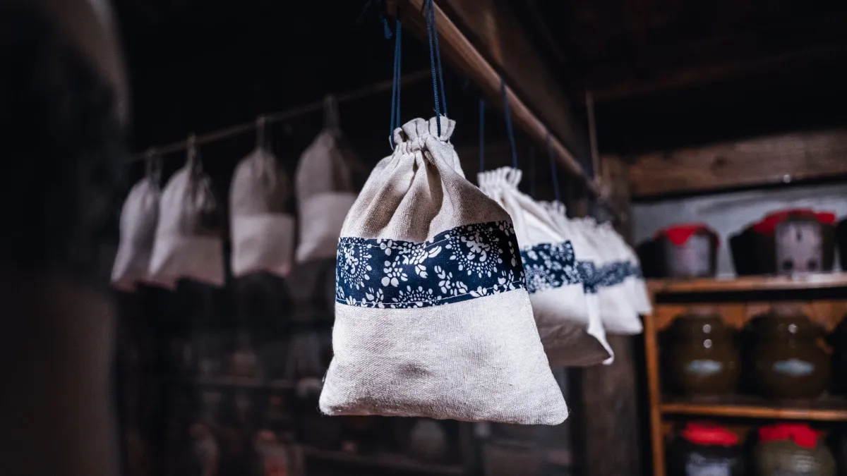 Sacos de tecido natural para guardar roupas de cama em uma prateleira