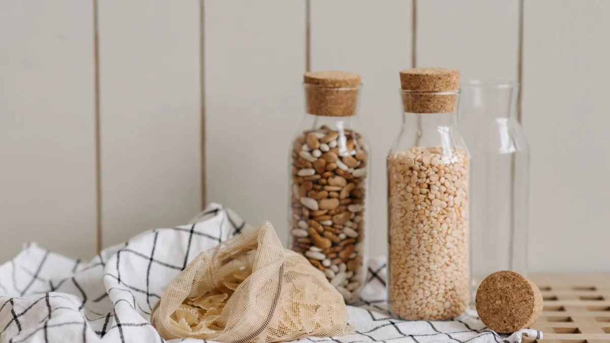Saquinho de tecido com arroz cru dentro de um pote de vidro vazio