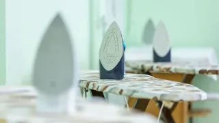 Tábua de passar roupa com manchas escuras de mofo na capa de tecido.