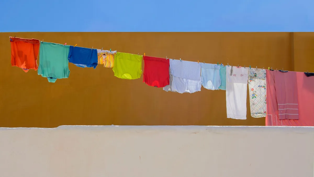 Vários panos de limpeza limpos e coloridos pendurados em um varal ao ar livre.